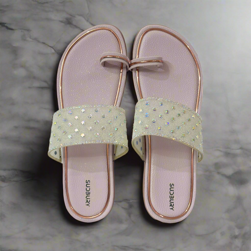 Pair of light gray sandals with decorative straps on a pink background
